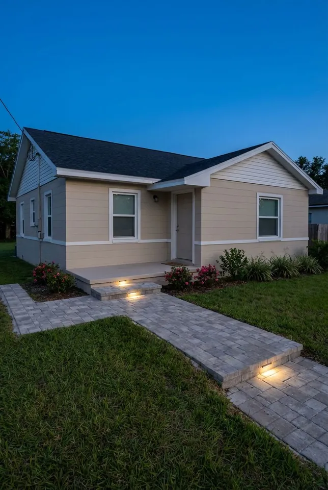 Concept rendering at dusk: gray paver walk and a single step lit by recessed fixtures